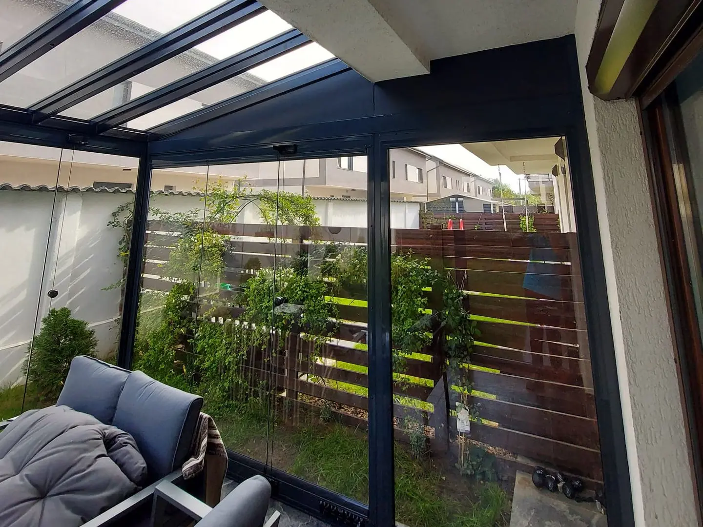 Terasă protejată cu acoperiș de sticlă și închideri glisante în București