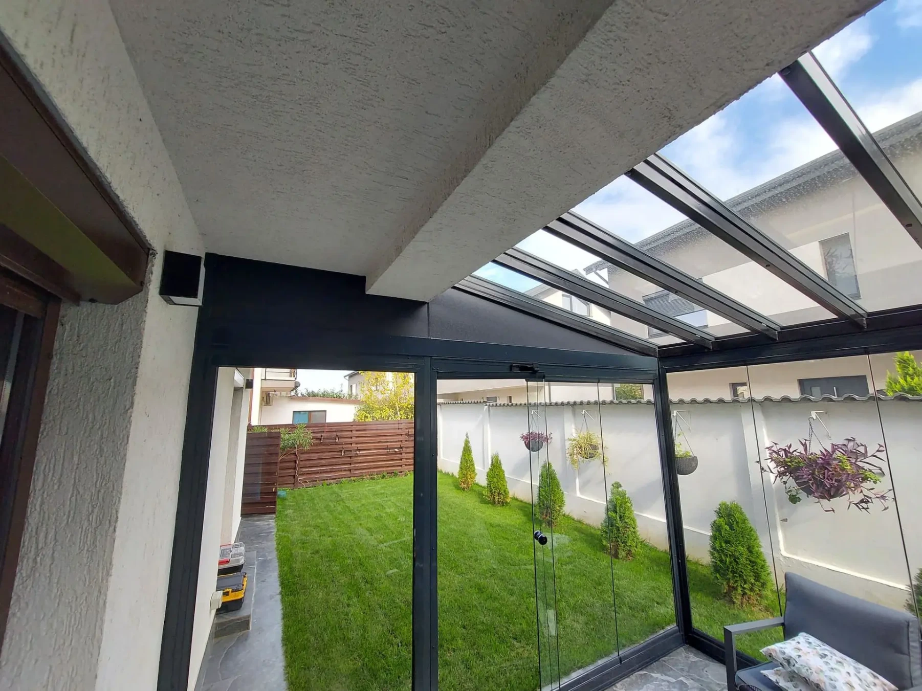 Terasă protejată cu acoperiș de sticlă și închideri glisante în București