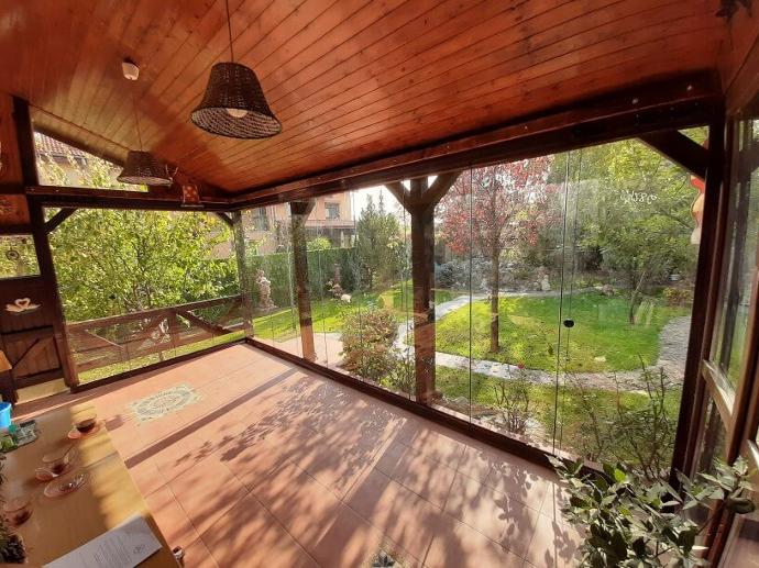 Amenajarea unui living open space cu bucatarie delimitarea spatiului cu ajutorul sticlei - teresa  cu vedere spre o curte inverzita, tavan din lemn