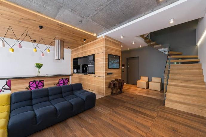 Amenajarea livingului cu hol avantaje si dezavantaje - hol cu living, scara lemn, televizor incorporat, canapea neagra, bar cu scaune roz
