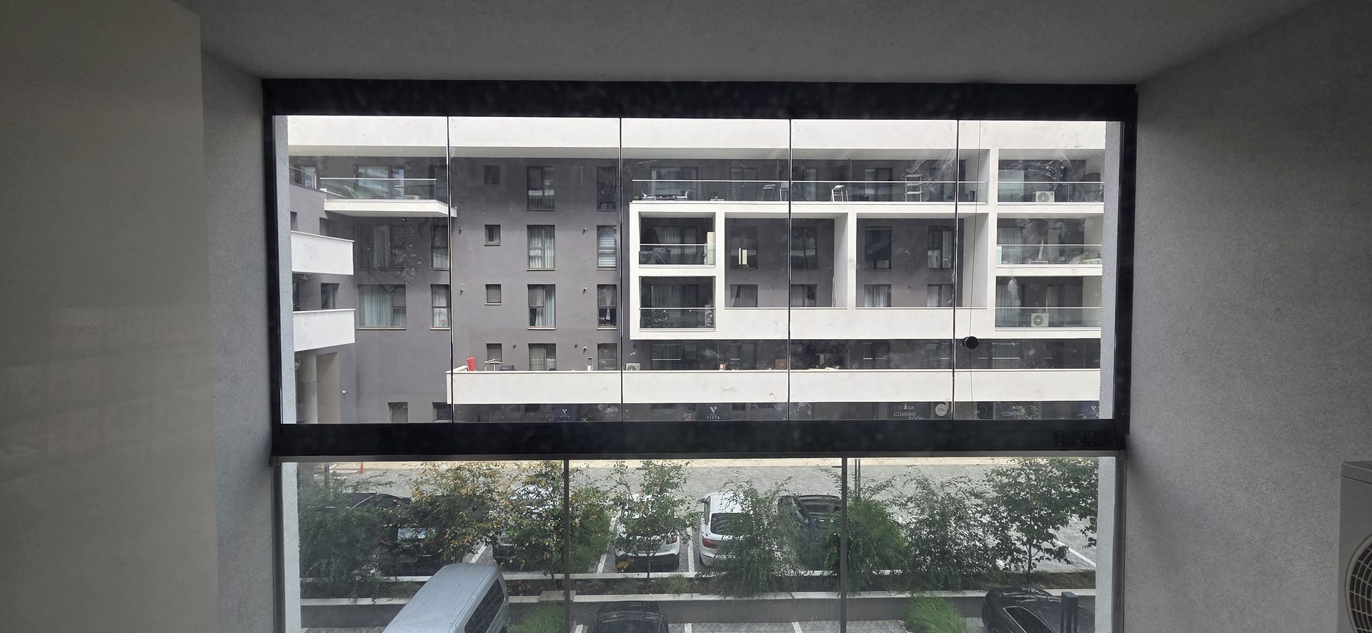 Balcon închis cu Valedo BKS în București: sistemul acoperă toată deschiderea, cu îmbinări între panouri și fără montanți verticali