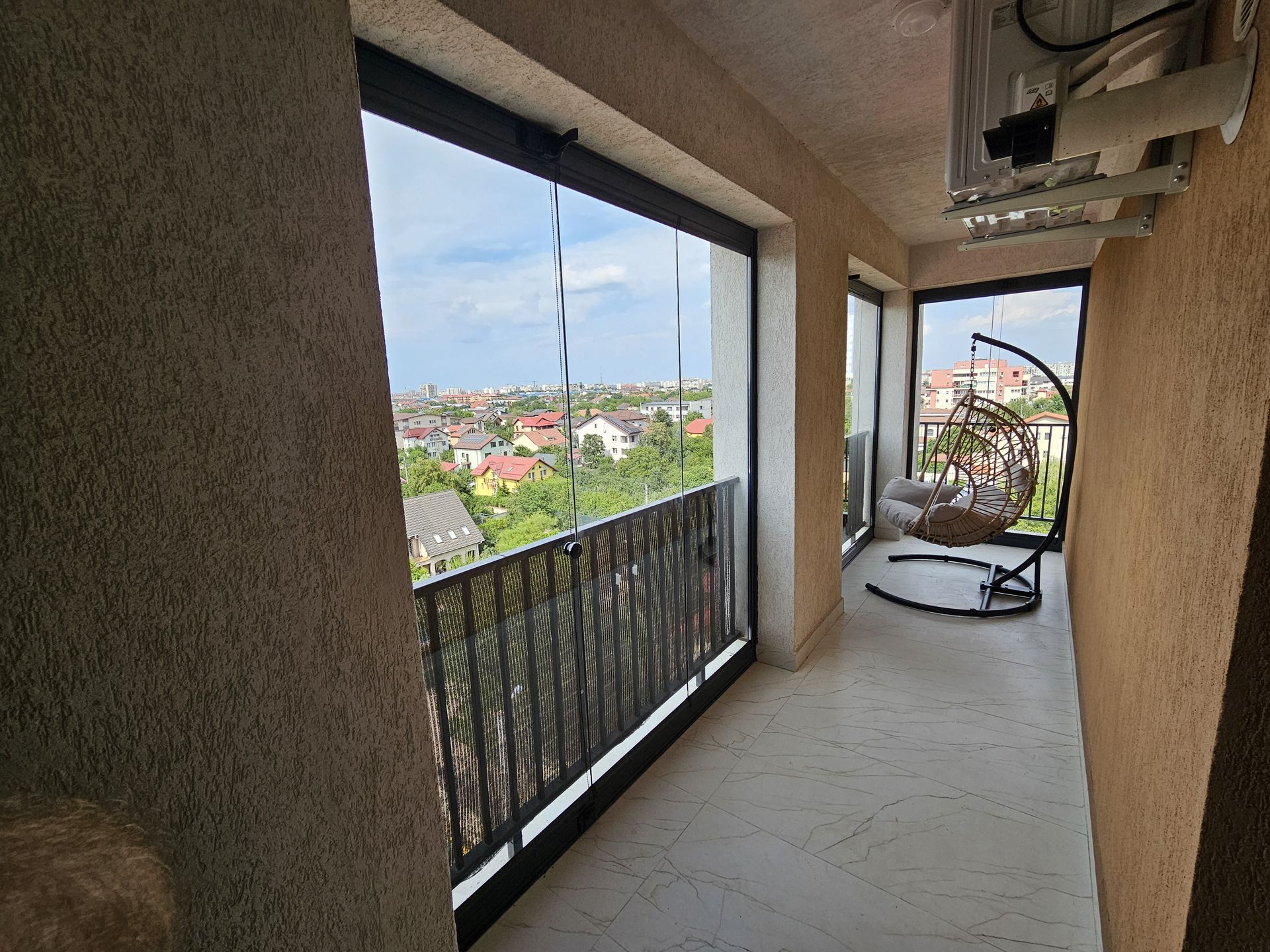 Latura vitrată complet cu Valedo BKS, văzută frontal, cu gresia deschisă la culoare — balcon București