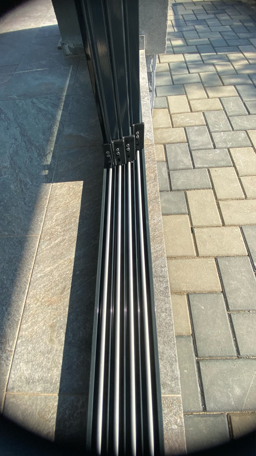 Detaliu al panourilor culisante cuplate — profile verticale subțiri, sticlă securizată de 10 mm