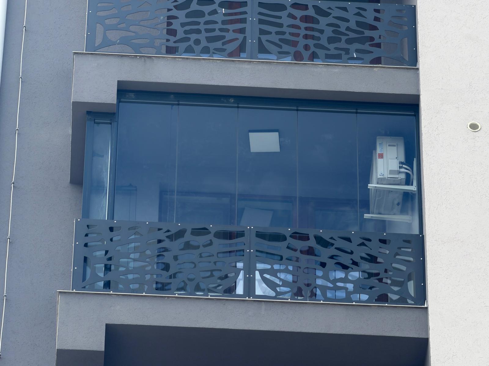 Fațada blocului din Suceava: balconul închis cu panouri Valedo BKS, sub un balcon rămas deschis, cu același parapet metalic perforat