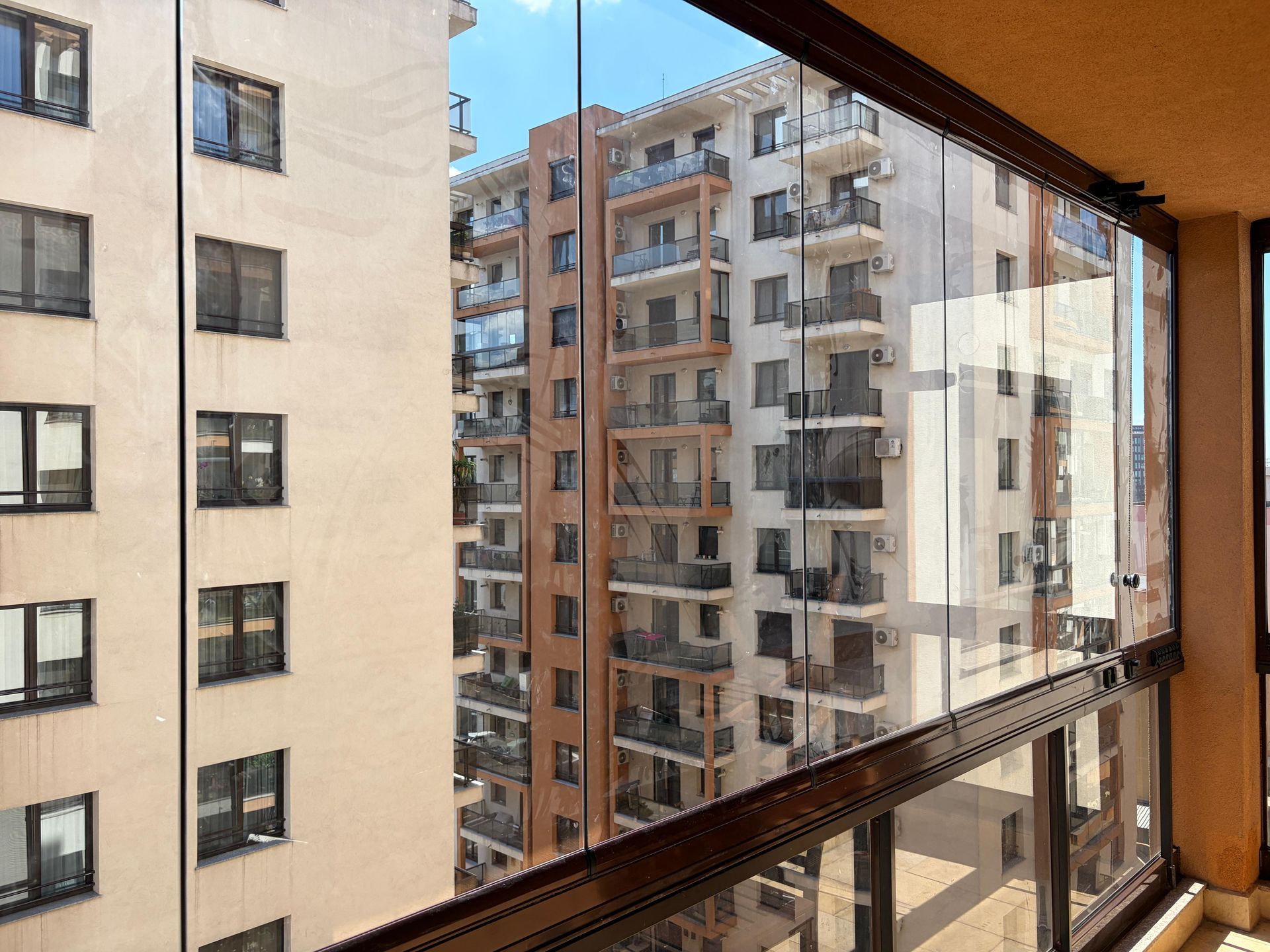 Colțul sistemului Valedo BKS: îmbinarea panourilor de sticlă fără profil vertical și mânerul panoului de acces — balcon București